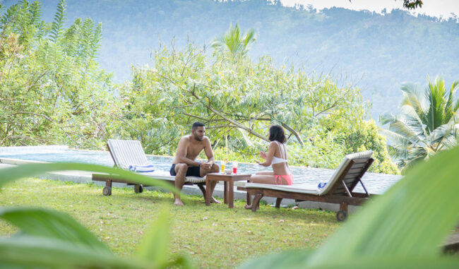 Mount Havana View Couple relaxing on sun loungers outdoors with a scenic green mountain view